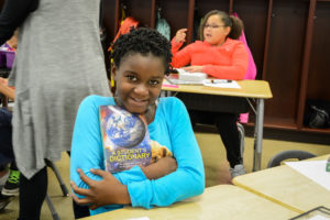 A Warren students shows off her new dictionary from the Warren Rotary Club