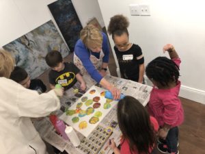 Students collaborate while painting on canvas