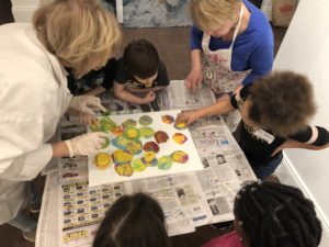 Students collaborate while painting on canvas