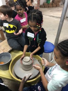 Students create pottery at potters wheel