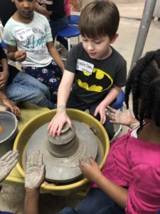 Students create pottery at potters wheel