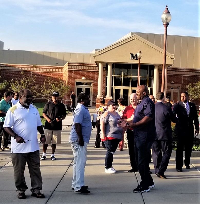 Volunteers greet students on the first day of school