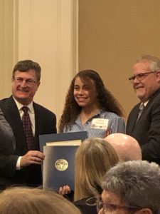 Elyssa receives his award.