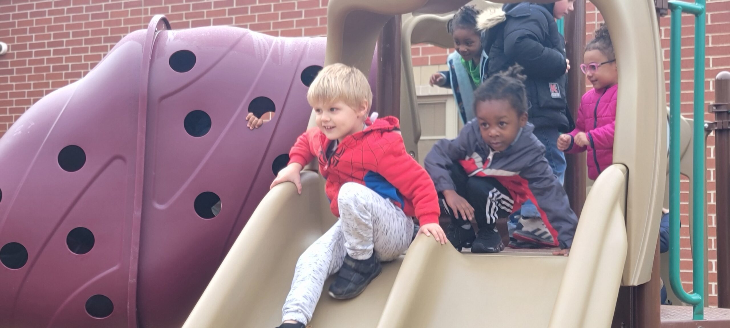 Equity & Access: Students & families help WCS staff cut the ribbon at the new PK playground at Harding