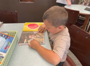 A student sits and looks at a book.