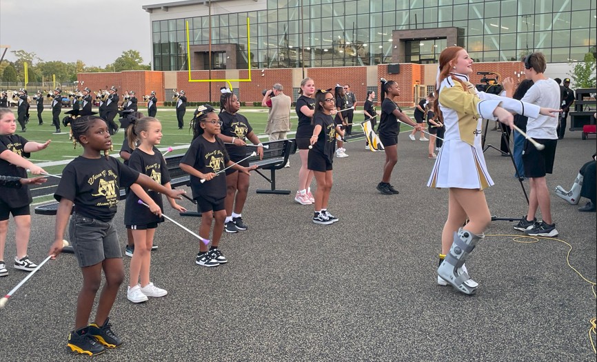 Students follow along as a Haring majorette leads.