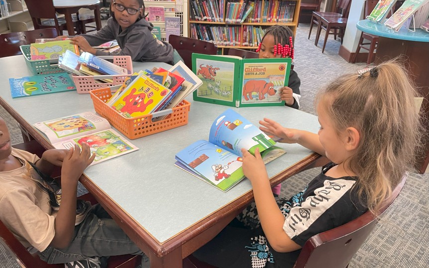 Students practice their book care techniques.