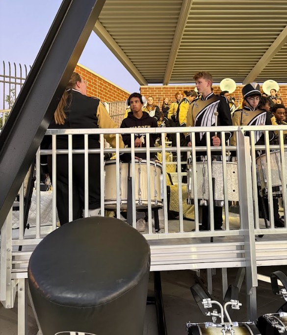 Students sit in the band shell with the Harding band.