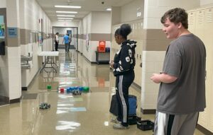 Students use remotes to control their robots.