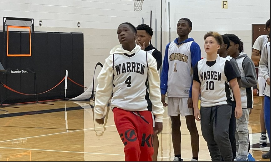 Players watching a teammate shoot a free throw