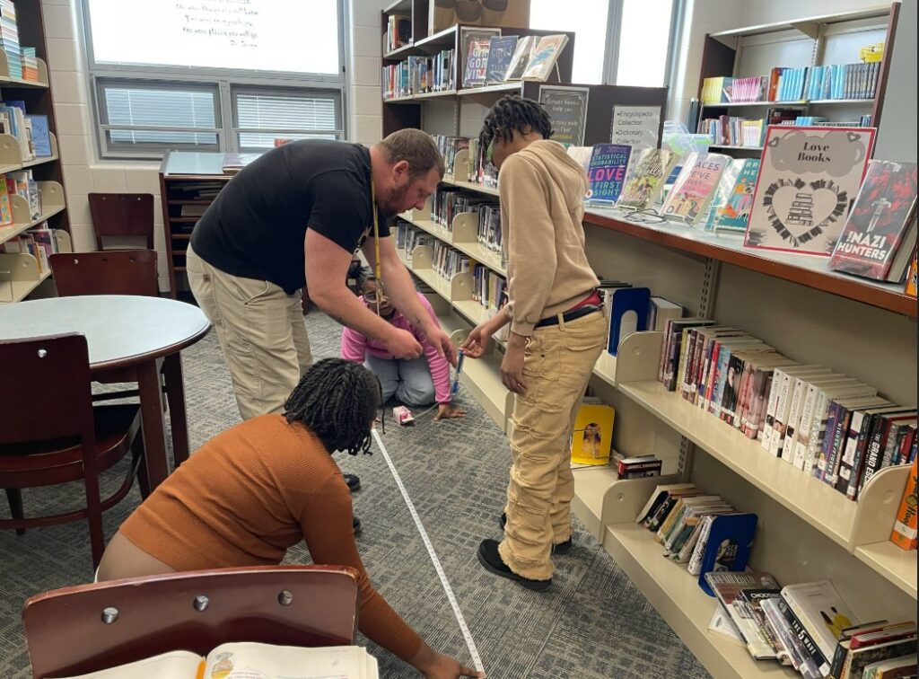 Mr. Irwin assists students with their experiment