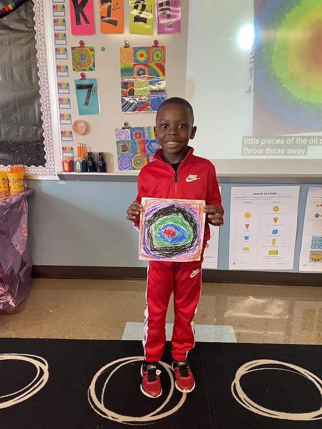 A student shows their finished artwork