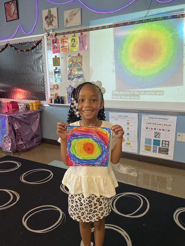 A first grader shows her artwork